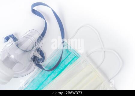 Medizinischer Ultraschall-Inhalator oder Vernebler Sauerstoffmaske und hygienische Gesichtsmasken auf weißem Hintergrund, Kopierraum Stockfoto
