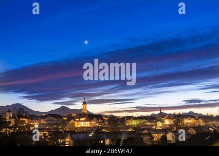 Die Stadt Traunstein mit den Chiemgauer Alpen im Hintergrund zur blauen Stunde des Sonnenuntergangs. Oberbayern, Deutschland Stockfoto