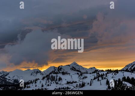 Orangefarbener Himmel bei Sonnenuntergang über Obertauern, Österreich Stockfoto