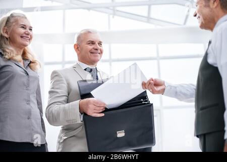 Bis zu schließen. Geschäftsmann empfangen Dokument von Mitarbeiter der Bank. Stockfoto