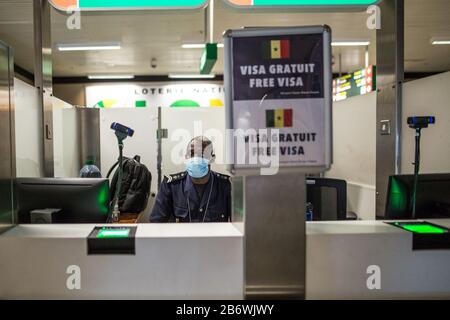 Dakar. März 2020. Das am 10. März 2020 aufgenommene Foto zeigt einen senegalesischen Einwanderungsbeamten, der bei der Arbeit in Dakar, Senegal, Gesichtsmaske trägt. Das senegalesische Ministerium für Gesundheit und Soziales bestätigte am Mittwoch den fünften Fall des Landes der COVID-19. Um zu verhindern, dass weitere Fälle in den Senegal eindringen, haben die Behörden des internationalen Flughafens Blaise Diagne nach der Richtlinie des senegalesischen Ministeriums für Gesundheit und soziale Aktion alle notwendigen Maßnahmen zur Aufdeckung von Fällen des neuartigen Coronavirus intensiviert. Kredit: Eddy Peters/Xinhua/Alamy Live News Stockfoto