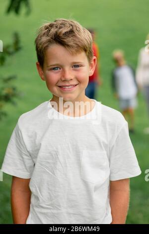 Eine Vorderansicht eines kleinen Jungen, der lächelt und die Kamera betrachtet. Stockfoto