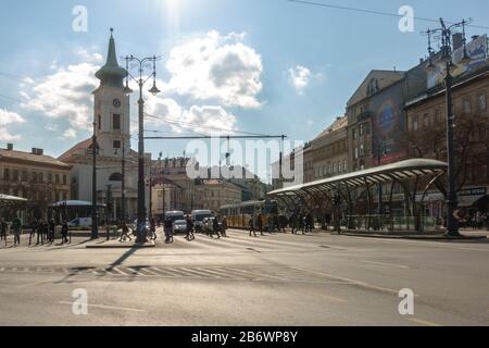 Die Leute, die die Straße zur Kalvin ter Tram Haltestelle in Budapest, Ungarn überqueren Stockfoto