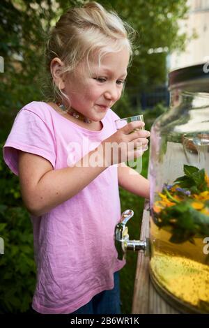 Kinder, die Lebensmittel untersuchen. Serie: Zubereitung eines Kräutergetränks. Verkostung des fertigen Getränks. Lernen nach dem Reggio-Pädagogik-Prinzip, spielerisches Verständnis und Entdeckung. Deutschland. Stockfoto