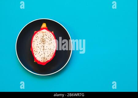 Pitaya. Die Nahaufnahme reifer Drachenfrucht auf Platte auf gelbem Grund. Stockfoto