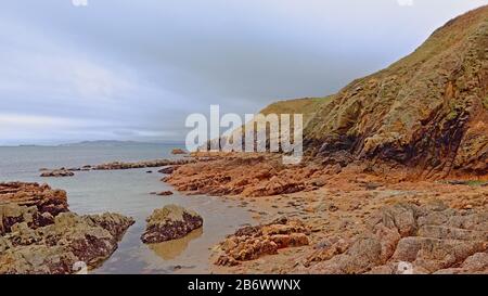 Felsige Klippen und Strand entlang der Nordseeküste von howth, Dublin, irland an einem bewölkten Tag, Stockfoto