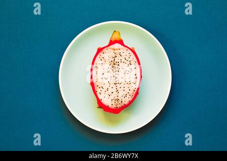 Pitaya. Die Nahaufnahme reifer Drachenfrucht auf Platte auf gelbem Grund. Stockfoto