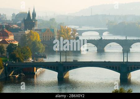 Dies ist ein allgemeiner Blick auf Prag im Herbst. Berühmte Brücken über die Moldau werden durch den Nebel ausgesticht. Stockfoto