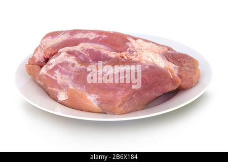 Roher Gigot auf Keramikplatte. Isoliert auf weißem Hintergrund mit Spiegelreflexion. Mit Beschneidungspfad. Mit Vektorpfad. Schweinegelenk auf weißem bg. Raw Stockfoto