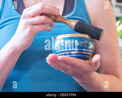 Haulerwijk - 07. märz 2020: Haulerwijk, Niederlande. Nahaufnahme der indischen Gesangsschüssel in der Hand der Frau. Meditations- und Entspannungskonzept Stockfoto