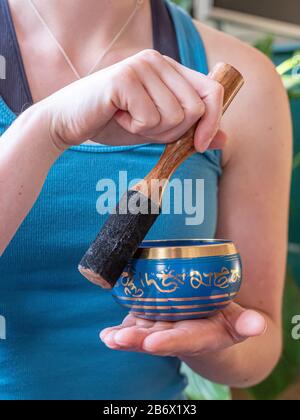 Haulerwijk - 07. märz 2020: Haulerwijk, Niederlande. Nahaufnahme der indischen Gesangsschüssel in der Hand der Frau. Meditations- und Entspannungskonzept Stockfoto