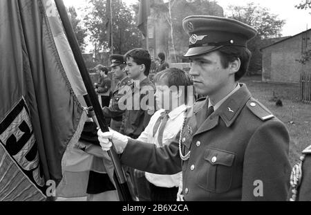 30. November 1984, Sachsen, Eilenburg: Mit einem Fahnenrollenaufruf von Pionieren, FDJ-Mitgliedern und Soldaten der nationalen Volksarmee erhält eine Schule in einem Dorf bei Eilenburg Mitte der 1980er Jahre das Ehrenbanner eines antifaschistischen Widerstandskämpfers. Genaues Aufnahmedatum nicht bekannt. Foto: Volkmar Heinz / dpa-Zentralbild / ZB Stockfoto