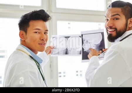Zwei Radiologieärzte mit Röntgenstrahlen in den Händen bei der Arbeit Stockfoto