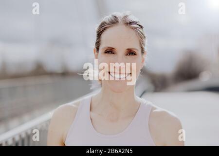 Porträt einer jungen sportlichen Frau in der Stadt mit Sportswear. Portrait einer jungen Sportlerin in der Stadt in der Trainingssiedlung Stockfoto