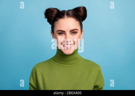 Closeup-Foto der hübschen brünette Dame Teenager zwei niedliche lustige Brötchen gute Laune strahlende weiße Zähne Lächeln tragen warm grün Turtleneck Pullover isoliert Stockfoto