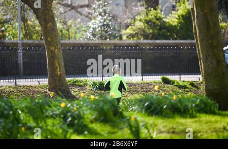 Brighton UK 12. März 2020 - EIN Läufer genießt das sonnige, aber kalte Wetter durch Das Niveau im Stadtzentrum von Brighton heute. Kredit: Simon Dack / Alamy Live News Stockfoto