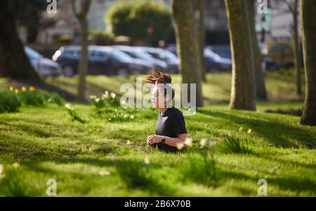 Brighton UK 12. März 2020 - EIN Läufer genießt das sonnige, aber kalte Wetter durch Das Niveau im Stadtzentrum von Brighton heute. Kredit: Simon Dack / Alamy Live News Stockfoto