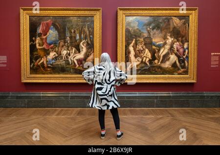 Die Historikerin Mary Beard sieht 'Diana and Actaeon' (links) und 'Diana and Callisto', Teil der Poesie-Serie von Titian, die große griechische, mythologische Gemälde umfasst, die in der Ausstellung "Titian: Liebe, Begierde, Tod" in der National Gallery in London zu sehen sind. Die Ausstellung bringt erstmals seit dem späten 16. Jahrhundert die sechs Gemälde in ihrer Gesamtheit zusammen. Stockfoto