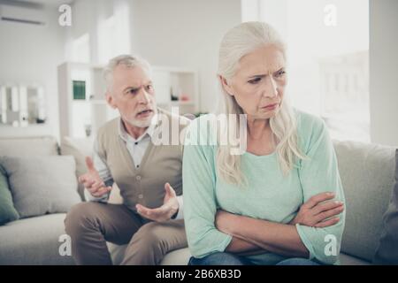 Nahaufnahme von trauriger verärgerter langhaariger alter Oma will ihrem strengen Ehemann, der Ansprüche sendet, nicht zuhören Stockfoto