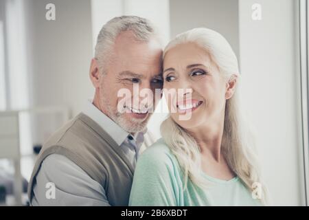 Nahaufnahme der Großeltern echte Liebhaber, die in der Wohnung mit braunen Pullovern aus Teelosenbraun aussehen Stockfoto