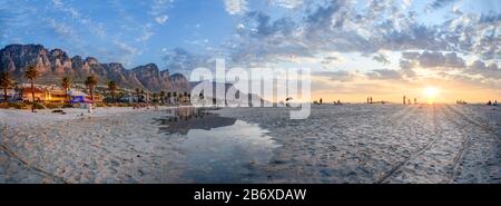 Panorama mit Abendstimmung am Strand von Camps Bay, im Hintergrund die "12 Apostles", in der Nähe von Kapstadt in Südafrika Stockfoto