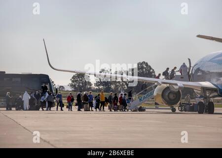 San Francisco, USA. März 2020. Am Oakland International Airport in Oakland, Kalifornien, den Vereinigten Staaten, am 11. März 2020 sind die Menschen von der Kreuzfahrtschifflinie Grand Princess bis hin zu einem Flugzeug auf dem Weg zu bestimmten Scheck- und Quarantäneplätzen ausgestiegen. Der Transport von Passagieren, die von der an Coronavirus erkrankten Grand Princess ausstiegen, wird seit dem Andocken des Kreuzfahrtschiffs am Hafen von Oakland im US-Bundesstaat Kalifornien durchgeführt. Kredit: Li Jianguo/Xinhua/Alamy Live News Stockfoto