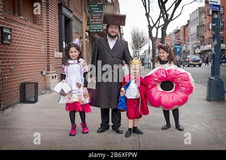 Porträt einer orthodoxen jüdischen Familie auf Purim. Die Kinder tragen Kostüme wie die Urlaubstradition. Williamsburg, Brooklyn, New York. Stockfoto