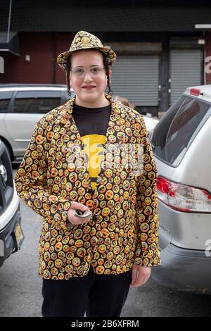 Ein junger Satmar jüdischer Schüler in seiner Emoji-Jacke und hat Purim-Kostüm heraus, um Nächstenliebe für seine Schule zu sammeln. In Williamsburg, Brooklyn, New York . Stockfoto