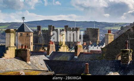 Die Burg Conwy liegt auf der anderen Seite der Dächer der Stadtmauern in Wales Stockfoto