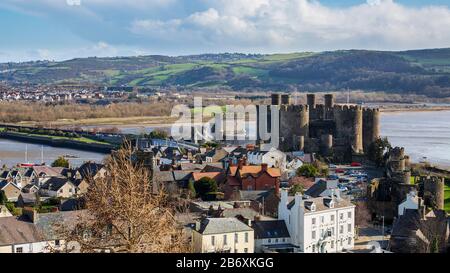 Die Burg Conwy liegt auf der anderen Seite der Dächer der Stadtmauern in Wales Stockfoto