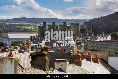 Die Burg Conwy liegt auf der anderen Seite der Dächer der Stadtmauern in Wales Stockfoto