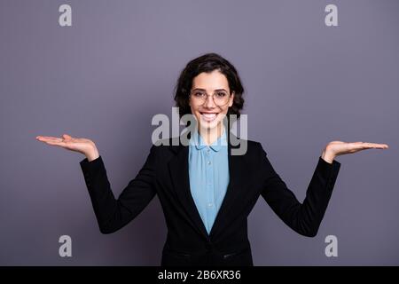 Portrait des charmanten schönen Jahrtausend entscheiden Sie sich für Promo-Anzeigen Optionen gewellten lockigen Haarschnitt isoliert edle Outfit grau Hintergrund Stockfoto