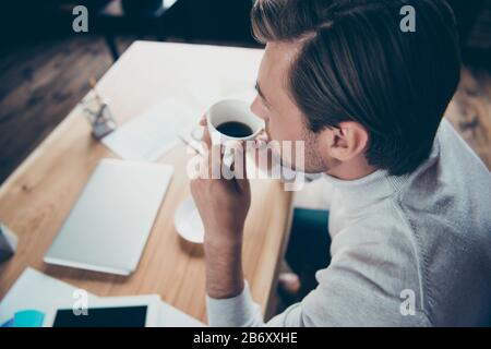 Nahaufnahme über einem hohen Blickwinkel Seitenansicht Porträt des attraktiven Content Leader Unternehmen Direktor Immobilien Spezialist für das Trinken von heißem Kaffee bei Stockfoto