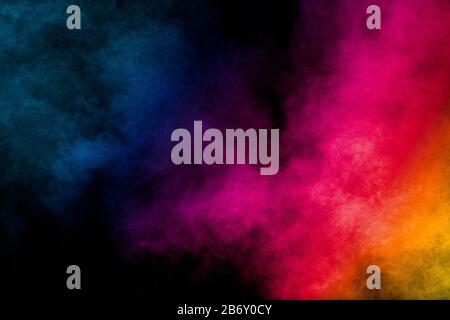 Mehrfarbige Partikel explodieren auf schwarzem Hintergrund.Bunter Staubefall auf dunklem Hintergrund. Stockfoto
