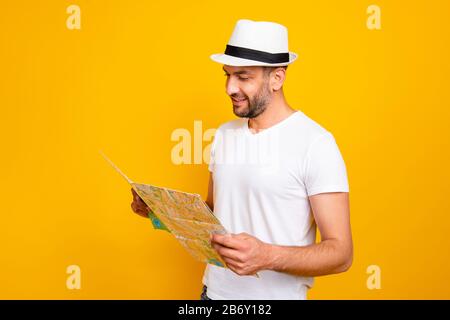 Porträt seines hübsch aussehenden fröhlichen fröhlichen Kerls mit weißem T-Shirt, das die Lesekarte untersucht, isoliert über strahlendem lebhaftem Glanz Stockfoto