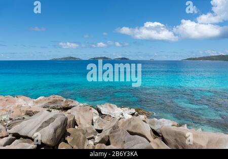 Das schöne türkisblaue Wasser vor der Küste, auf der Insel La Digue auf den Seychellen. Stockfoto