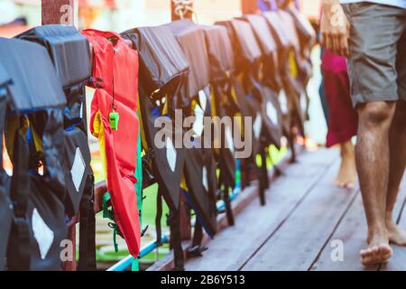 Eine grüne Pfeife mit roter Lebensjacke, die am Geländer um den Gehweg hängt, damit die Passagiere sicher an den Docks sind. Stockfoto