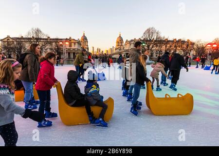 England, London, Greenwich, Erwachsene und Kinder Eislaufen im Queens House Ice Rink Stockfoto