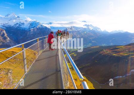 Grindelwald, Schweiz - Oktober 10, 2019: Leute die Bilder auf Sky Cliff Walk Metal Bridge auf den ersten Gipfel der Schweizer Alpen Berge, Schnee, Gipfel Pano Stockfoto