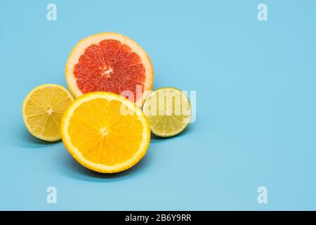 Verschiedene Zitruspapeten aus orangefarbener Limette und Grapefruit auf farbenfrohem Hintergrund, abstrakte Tapeten mit Kopierraum Stockfoto