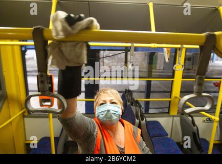 Ein Arbeiter, der eine Schutzmaske trägt, desinfiziert einen Personenkraftwagenbus als präventive Maßnahme gegen das COVID-19-Coronavirus in einem Trolleybusdepot.Vom 12. März bis 3. April 2020 führt die Ukraine eine dreiwöchige Quarantäne ein, um dem neuen Coronavirus COVID-19 wegen der weltweiten "ovid-19-Coronavirus-Epidemie" entgegenzuwirken. Die Quarantäne in der Ukraine sieht die Schließung von Bildungseinrichtungen, das Verbot von Massenversammlungen von mehr als 200 Personen, die Schließung von Luftdiensten mit einigen Ländern vor. Die Weltgesundheitsorganisation erklärte das Coronavirus am 11. März 2020 zu einer globalen Pandemie. Stockfoto