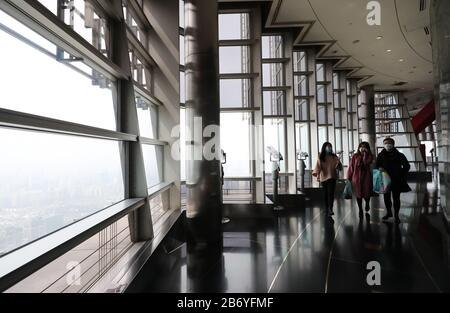 Shanghai. März 2020. Touristen sind auf der Aussichtsplattform des Jin Mao Tower im Osten Chinas Shanghai, 12. März 2020, zu sehen. Der Shanghai Tower, Chinas höchstes Gebäude, hat seine Touristenattraktion "Top of Shanghai Observatory" am Donnerstag wieder eröffnet. Zwei weitere Sehenswürdigkeiten begannen ab Donnerstag auch Touristen zu empfangen, darunter der Shanghai Oriental Pearl Tower und der Shanghai Jinmao Tower. Um MIT 'Shanghai Skyscraper Sceneries, Landmarks to Reopen' zu GEHEN Credit: Fang Zhe/Xinhua/Alamy Live News Stockfoto