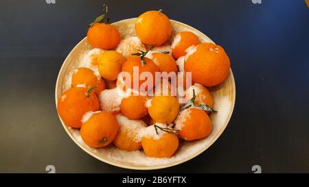 Verschneite Orangen in einer Holzschale Stockfoto