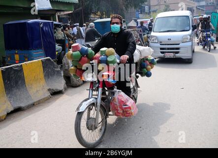 (200312) -- PESCHAWAR, 12. März 2020 (Xinhua) -- EIN Mann, der eine Gesichtsmaske trägt, fährt am 12. März 2020 ein Motorrad im nordwestpakistanischen Peshawar. Die bestätigten Fälle von COVID-19 stiegen in Pakistan auf 21, wobei ein neuer Fall in der Region Nord-Gilgit Baltistan (GB) am Donnerstag gemeldet wurde, sagten Beamte. (Xinhua/Saeed Ahmad) Stockfoto