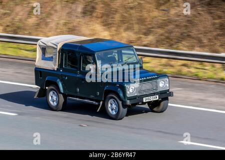 2010 Green Land Rover Defender 110County TD D/C; UK Fahrzeugverkehr, Transport, moderne Fahrzeuge, Salonwagen, bewegliche Fahrzeuge, Fahrzeug, Straßen, Motoren, Fahren auf der Autobahn M6 Stockfoto