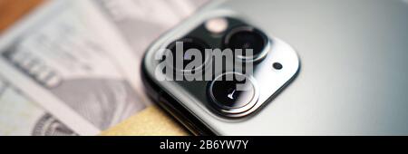 Das Handy wurde umgeschlagen und lag bei einem Haufen US-Dollar Stockfoto