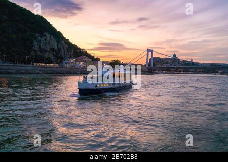 Boot mit Elisabeth Brücke und Hügel bei Sonnenuntergang Stockfoto