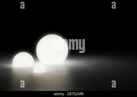 Drei warmleuchtende Kugellichtobjekte auf glänzendem modernen Industriebetonboden in einem großen dunklen Raum mit Kopierraum - 3D-Illustration Stockfoto