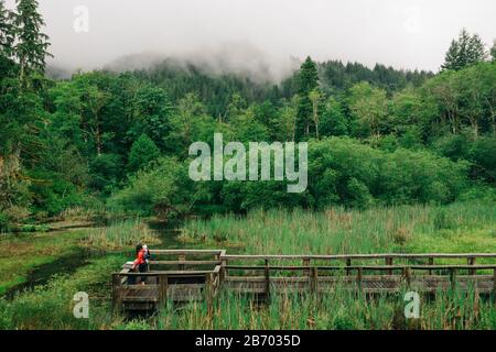 Ein junges Paar genießt eine Wanderung auf einer Promenade im pazifischen Nordwesten. Stockfoto