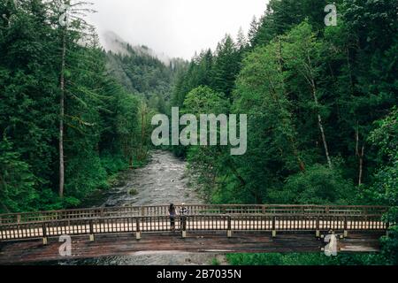 Ein junges Paar genießt eine Wanderung auf einer Promenade im pazifischen Nordwesten. Stockfoto